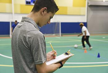 Physical Education Student writing on clipboard